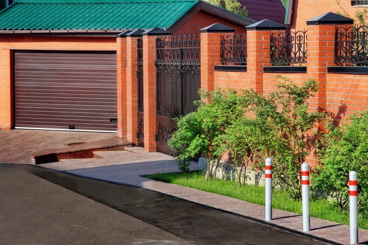 Высокий и толстый забор из красного лепного кирпича